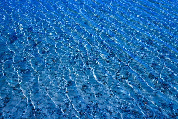 Blauw Wateroppervlak Met Rimpelingen Waardoor Zanderige Bodem Met Steentjes Zichtbaar — Stockfoto