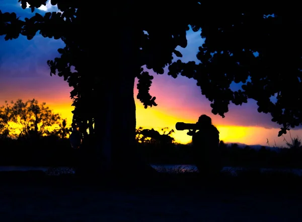 Gün batımındaki güzel anların fotoğraflarını çeken bir fotoğrafçının silueti.