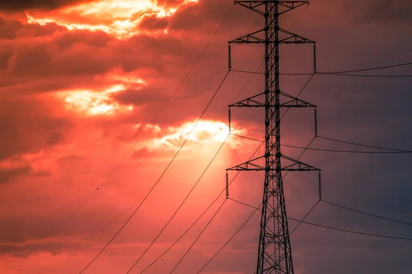 日落时的高压电塔和落日背景下的天空 — 图库照片