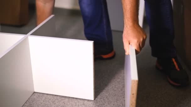 Homme assemblant de nouveaux meubles dans sa maison .