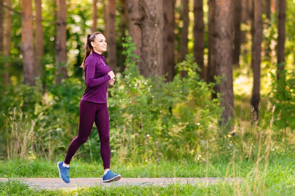Çalışan kadın. Kadın atlet açık havada parkta koşu. Fitness, spor ve ağırlık kaybı kavramı
