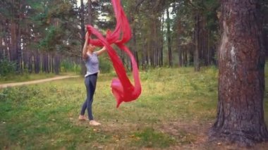 Genç kadın hava yoga egzersiz veya anti yerçekimi yoga açık havada pratik. Uçuş, fitness, streç, denge, sağlıklı yaşam tarzı. Hamak kullanan kadın.