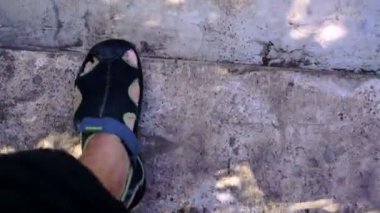 Bir adam taş merdivenlerden aşağı yürüyor.