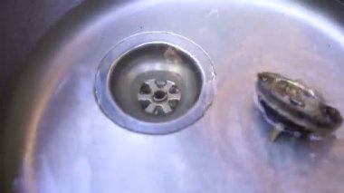 Metal evye. Adam tıpa lavabo ve boşa su akar dışarı alır