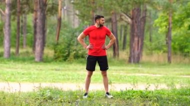 Erkek koşucu eğitimi. Parkta kaslarını esneten erkek sporcu. Sağlıklı, sağlıklı, sağlıklı bir yaşam tarzı. Spor, kardiyo, egzersiz konsepti