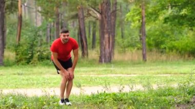 Erkek koşucu eğitimi. Parkta kaslarını esneten erkek sporcu. Sağlıklı, sağlıklı, sağlıklı bir yaşam tarzı. Spor, kardiyo, egzersiz konsepti