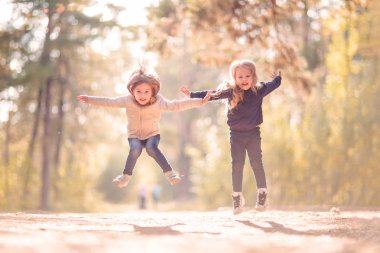 Atlama ve açık havada birlikte eğlenmek iki küçük kız