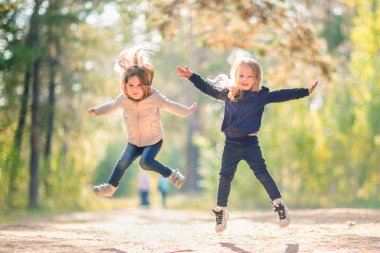 Atlama ve açık havada birlikte eğlenmek iki küçük kız