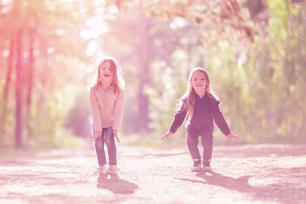 ジャンプして一緒に屋外の楽しみを二人の少女 — ストック写真