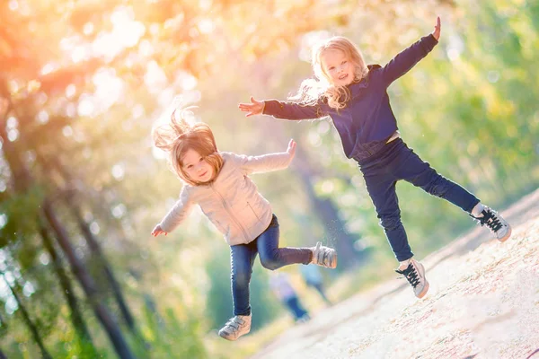 Två Små Flickor Hoppa Och Roligt Tillsammans Utomhus — Stockfoto