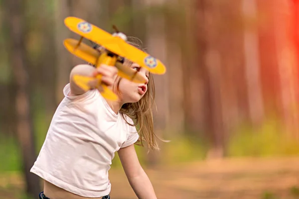 小さな女の子がおもちゃの飛行機を屋外で遊んで 旅の夢 — ストック写真