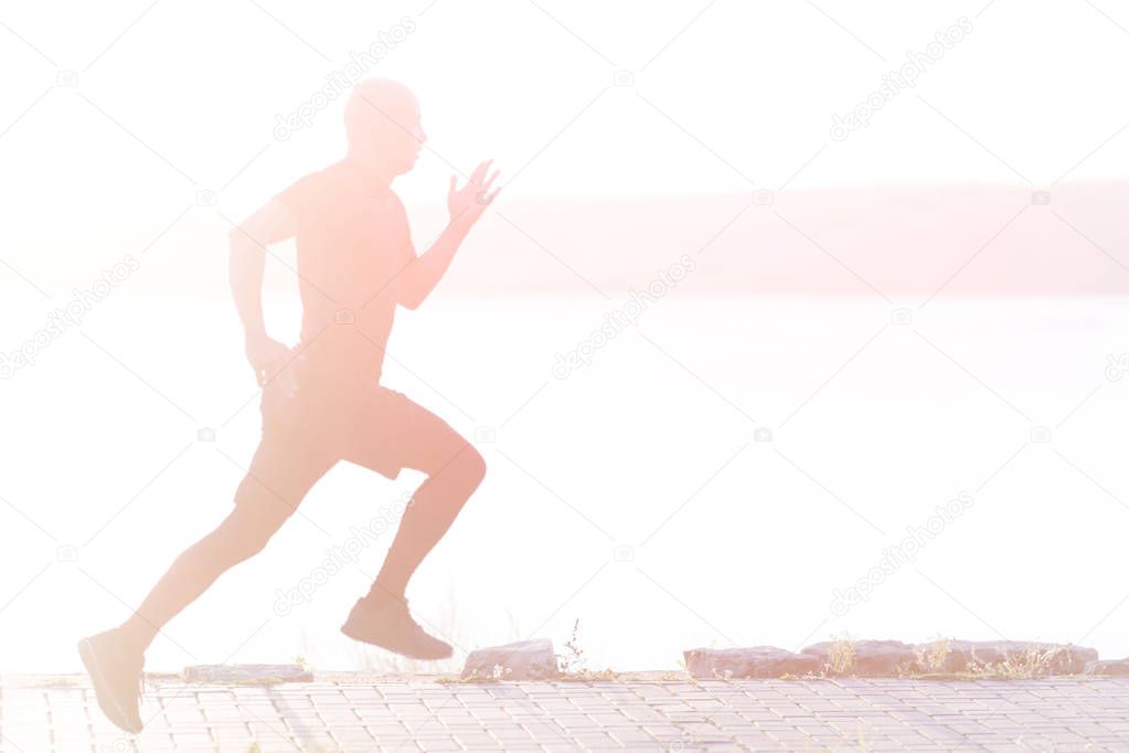 Running man. Male runner jogging outdoors. Fitness, sport and weight loss concept