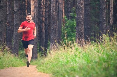 Çalışan adam. Parkta koşu Erkek atlet. Adam eğitim açık havada. Orman yolu üzerinde egzersiz. Sağlıklı, fitness, sağlıklı yaşam yaşam tarzı. Spor, kalbî, egzersiz kavramı