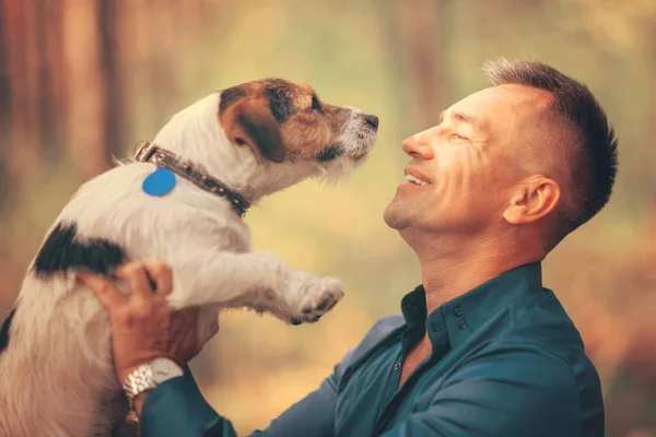 Parkta oynayan onun köpek olan adam. Onun hayvan sahibi hugs.
