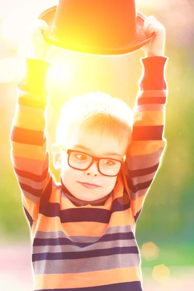 Zabawny Mały Chłopiec Okularach Trzymając Kapelusz Głowę — Zdjęcie stockowe