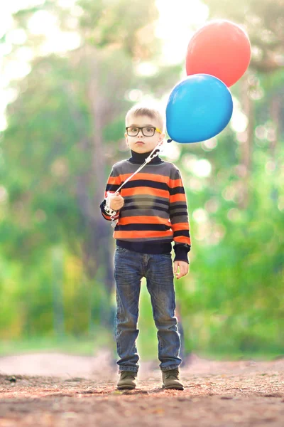 Smutny Chłopiec Okularach Zewnątrz Gospodarstwa Balony — Zdjęcie stockowe