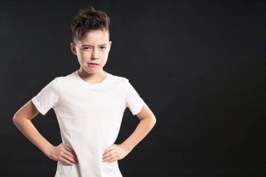 Siyah arka plan üzerinde kötü bir ruh hali içinde kızgın çocuk