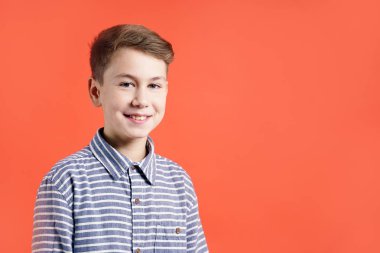 Kameraya kırmızı arka plan üzerinde seyir yakışıklı genç çocuk portresi.