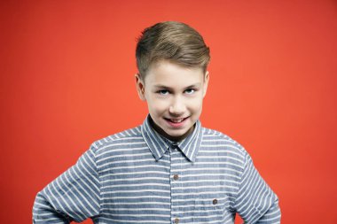 Kameraya kırmızı arka plan üzerinde seyir yakışıklı genç çocuk portresi.