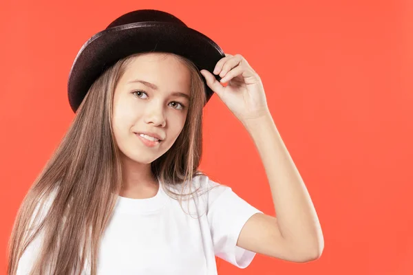 美丽的微笑的少女在一个黑色帽子在红色背景 — 图库照片