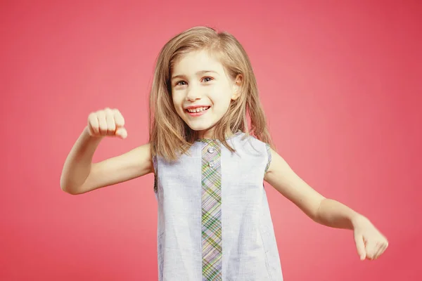 滑稽的小女孩跳舞在粉红色的背景 — 图库照片