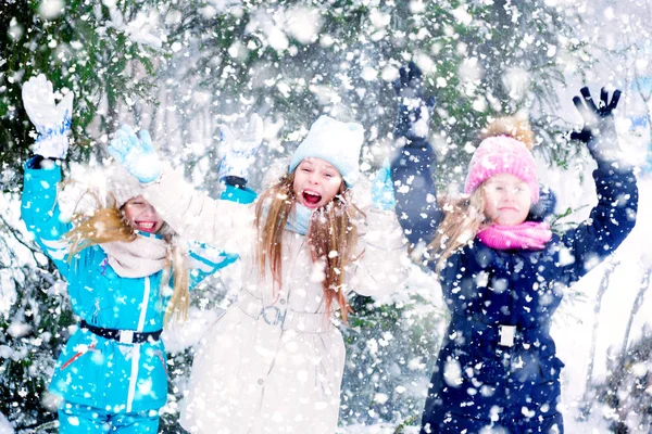 Três meninas felizes gritando e levantando as mãos em uma neve . — Fotografia de Stock