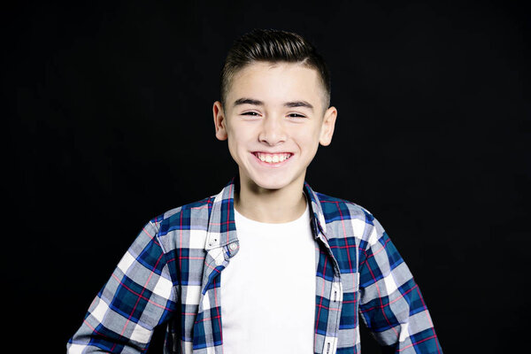 Портрет красивого счастливого мальчика, смотрящего в камеру на черном фоне
.