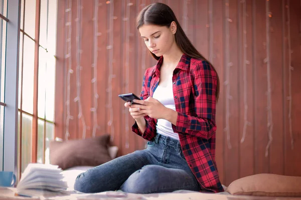 Dospívající Dívka Dívá Její Mobilní Telefon Vážným Výrazem Sedí Podlaze — Stock fotografie