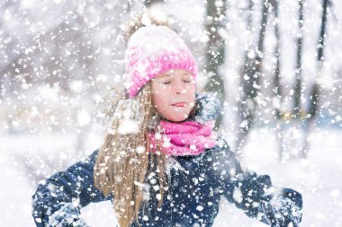 Sevimli kız çocuk gözleri kapalı ve bir kar tanesi ağzını ile çalışır.