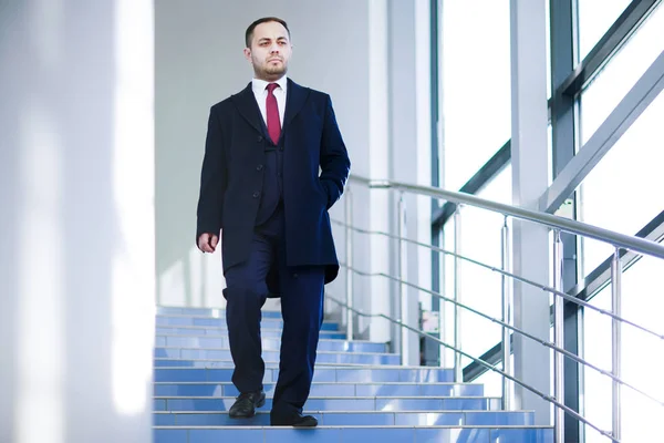 Um homem de fato de negócios desce as escadas . — Fotografia de Stock