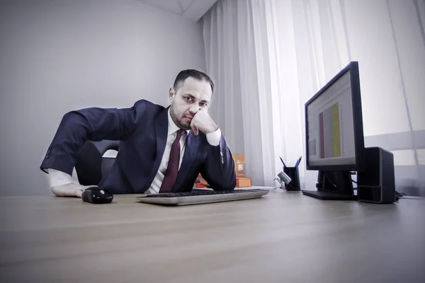 Un uomo d'affari premuroso seduto alla scrivania dell'ufficio . — Foto Stock