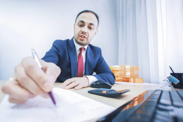 Een manager verwijst naar een document met pen in kantoor. — Stockfoto