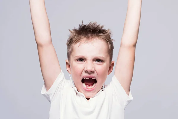 Θυμωμένος ξεδοντιασμένη ουρλιάζοντας μικρό αγόρι σε ένα άσπρο μπλουζάκι με βραχίονα — Φωτογραφία Αρχείου
