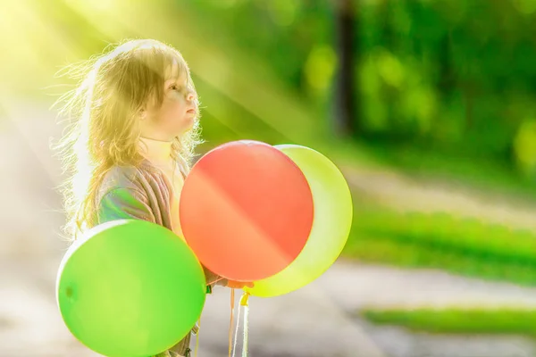 Allvarlig Liten Flicka Håller Tre Ballonger Närbild Bakgrund Grön Skog — Stockfoto