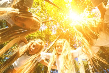Bir grup kız kendilerini sarılma seyir eğildi, bir daire, kurdu. Yaz ormanda yürümek. Parlak güneşli bir günde.