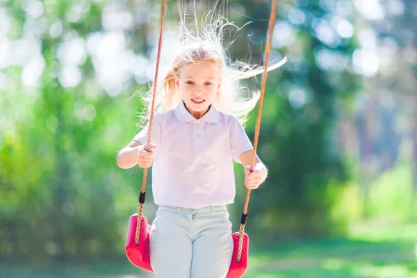 小さな女の子が森の屋外ブランコに揺れて — ストック写真