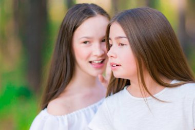 Genç kız yaz ormanda fısıldıyor. Yakın çekim.