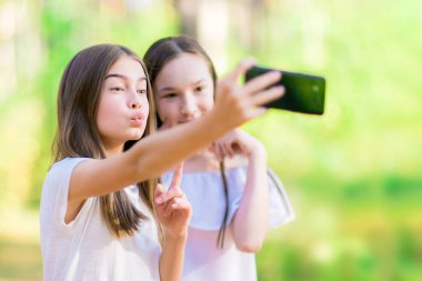 İki kız arkadaşım selfie orman olun. Yaz güneşli gün.