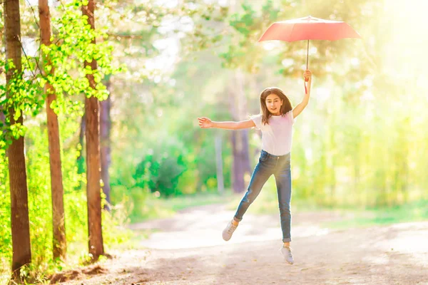 夏の森の赤い傘と女の子ティーンエイ ジャーにジャンプします 明るく晴れた日 — ストック写真