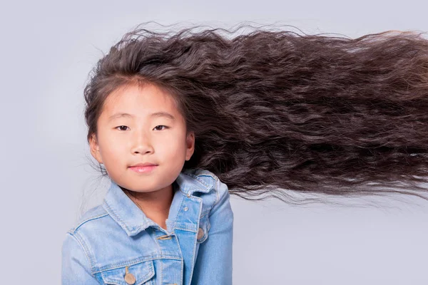 Красивые вьющиеся волосы. Азиатская девочка с длинными волосами на горизонте — стоковое фото
