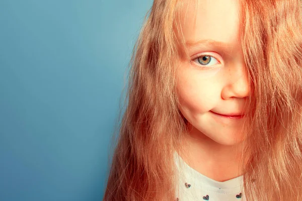 Hair covers face. Little girl with beautiful blond hair
