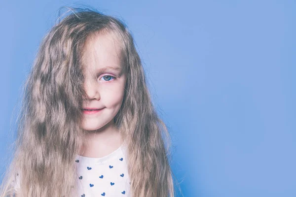 Волосы закрывают лицо. Маленькая девочка с красивыми светлыми волосами — стоковое фото
