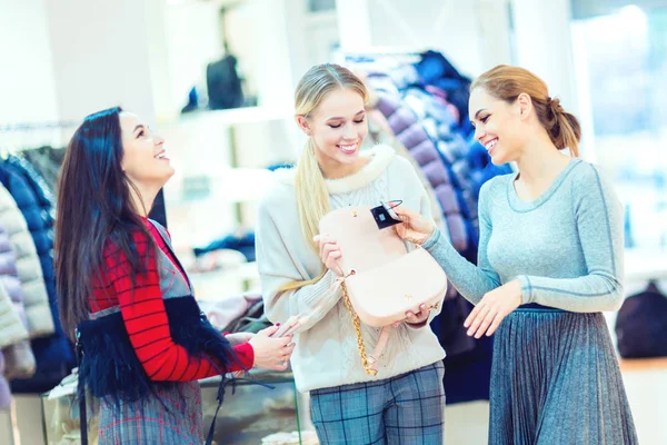 Compras. Un grupo de chicas felices elige una bolsa en una boutique — Foto de Stock