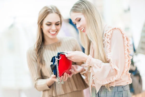 Compras. Chicas alegres en una boutique mirando un embrague. Juega. — Foto de Stock