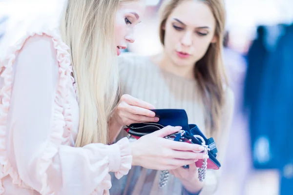 Compras. Chicas alegres en una boutique mirando un embrague. Juega. — Foto de Stock