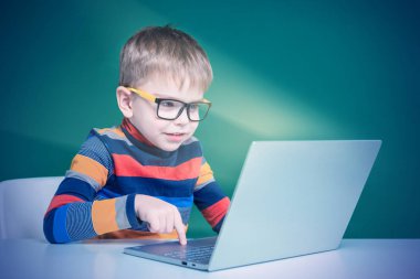 Gözlük ile neşeli çocuk laptop oynar. Close. Yeşil Bac