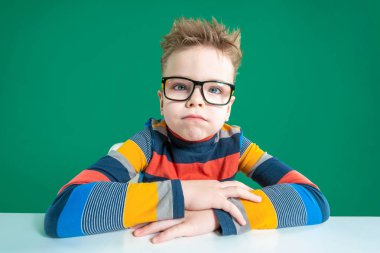 Gözlüklü, kıç göz, masada oturan bir çocuk. Close