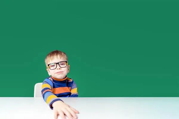 Funny boy with glasses sitting at the table. Copy space — Stock Photo, Image