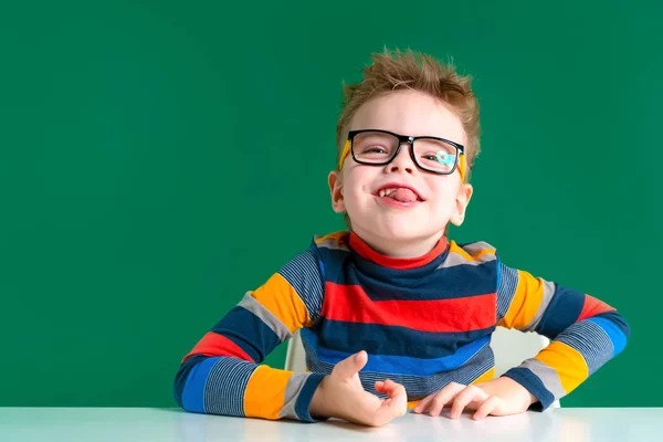 Cheerful boy with glasses shows tongue. Close-up — Stock Photo, Image
