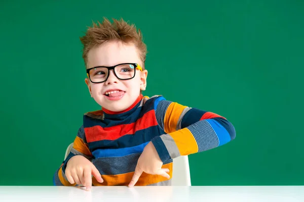 The gamine boy in glasses shows tongue. Close-up — Stock Photo, Image